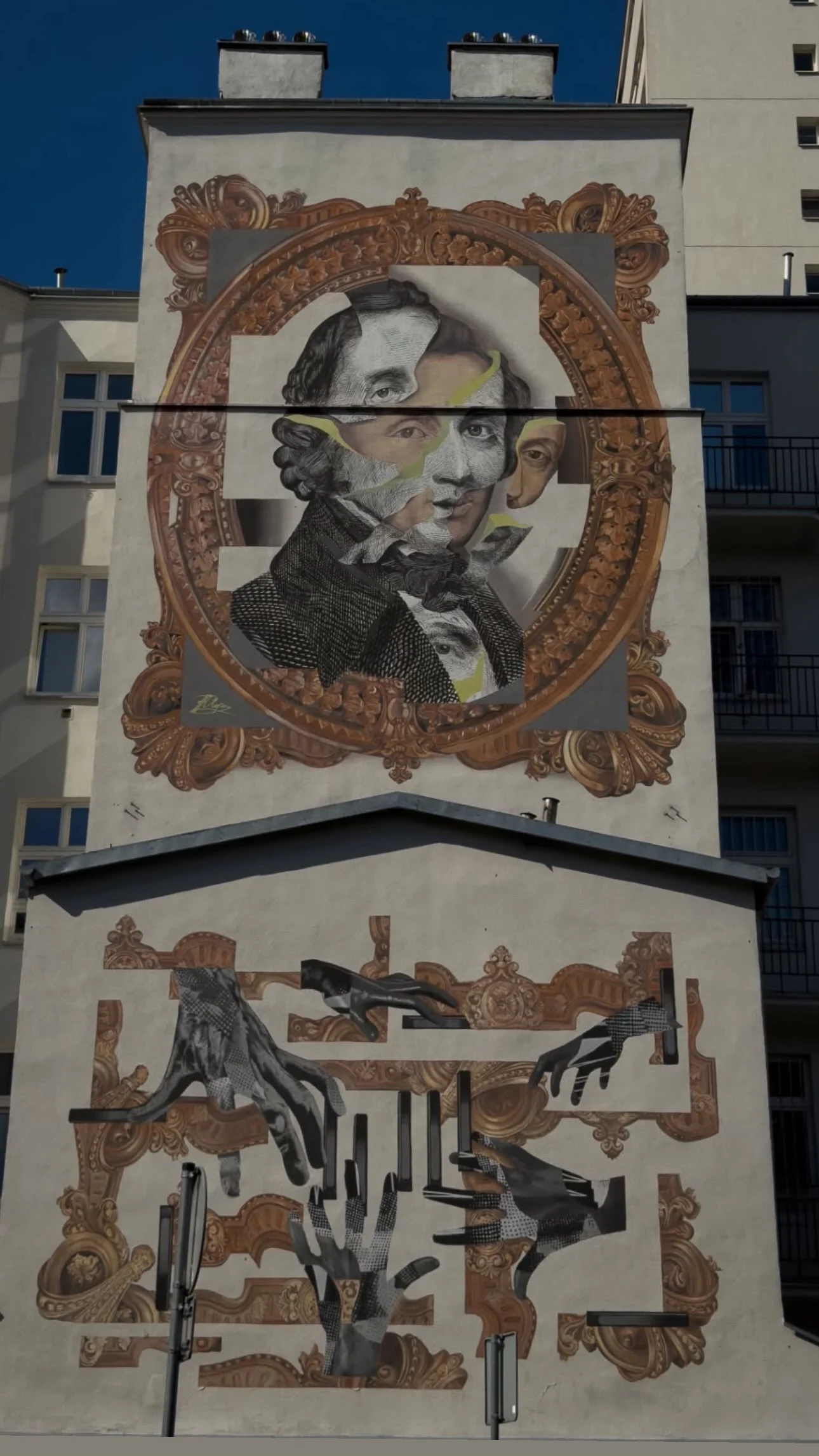 A large, fragmented portrait mural inside a painted ornate frame on a building wall.